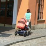 Colorful image of a mom pulling her well-equipped baby carriage