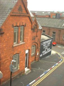 Derry protestant neighborhood with defiant curb colors and wall slogan