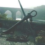 Old railroad bridge and ship's anchor