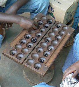 Men playing a game called "Igisoro".  The board is divided