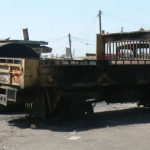 A child plays on a charred truck. Violence is a