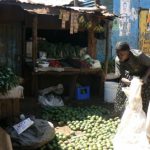 Sorting limes for sale at a fruit stand.