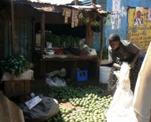 Sorting limes for sale at a fruit stand.