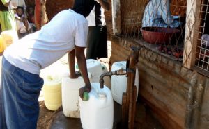 Filling water jugs at a common faucet.