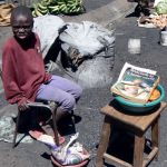 Child vendor selling fried bread during a lull in the