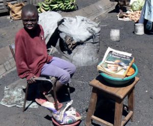 Child vendor selling fried bread during a lull in the