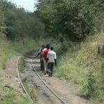 Workers walk along the abandoned rail tracks that used