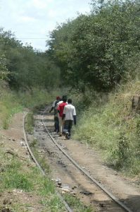 Workers walk along the abandoned rail tracks that used