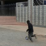 A boy and his simple toy running past the Catholic