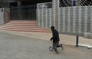 A boy and his simple toy running past the Catholic