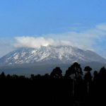 Mount Kilimanjaro rises high and majestic above the rural and