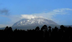 Mount Kilimanjaro rises high and majestic above the rural and