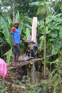 Sawing planks by hand along the village road in Marangu. As
