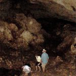 Exploring a cave in the extensive volcanic rocks on the