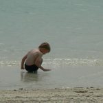 Tourist child from Scandinavia plays on the beach.