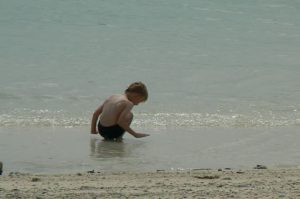 Tourist child from Scandinavia plays on the beach.