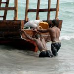 Stone Town port - pushing a fishing boat out to