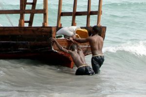 Stone Town port - pushing a fishing boat out to