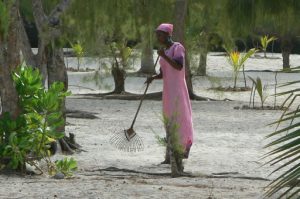 Pretty woman raking the sand at Sunset Cottages Resort