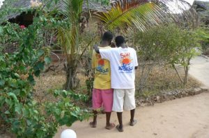 Two friends listening to a cell phone at Sunset Cottages