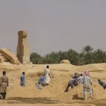 Moving sand piles by hand.