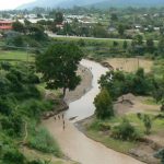 Kids playing in a river near a village