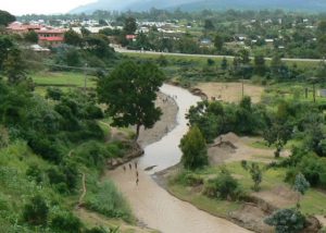 Kids playing in a river near a village