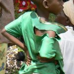 Impoverished boy watching women's rally.