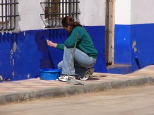 Woman paints wall