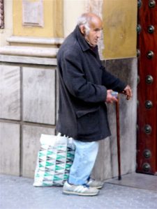 Seville - beggar at the door of a church.