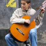 Young boy playing for coins in