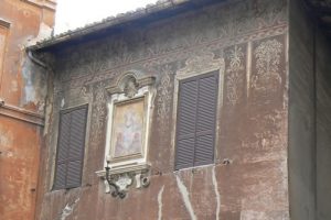 House with fading exterior frescos;  Rome has such a density