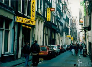 People walking next to a gay cinema.