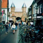 Street view with pedestrians and parked bicycles.