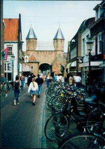 Street view with pedestrians and parked bicycles.