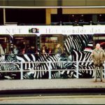 Man waiting in front of a train with zebras on