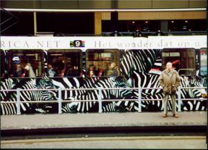 Man waiting in front of a train with zebras on