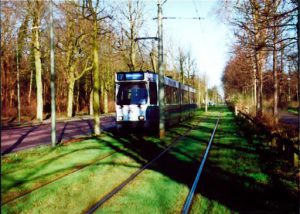 An approaching train with trees surrouding the area.