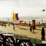 View of waves crashing in and people enjoying the day.