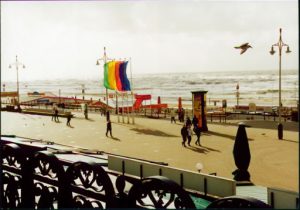 View of waves crashing in and people enjoying the day.