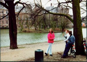 People gathered by bicycles talking.