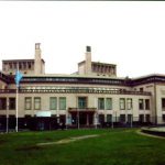 Building with a water fountain and flag in front.