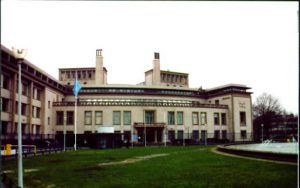 Building with a water fountain and flag in front.