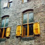 Close up view of brick building with window shutters.