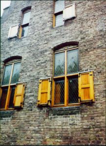 Close up view of brick building with window shutters.