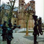 Statues standing in front of buildings.