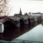 Large stone bridge leading across the water.