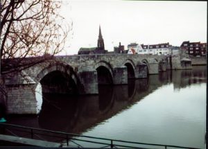 Large stone bridge leading across the water.