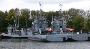 Kolobrzeg harbor with naval ships.