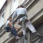 Workman Hanging Banner on Building